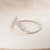 Shown here is "Fala", a feather-style tracer wedding band that is made to go with some of our engagement rings, facing left (email for options).