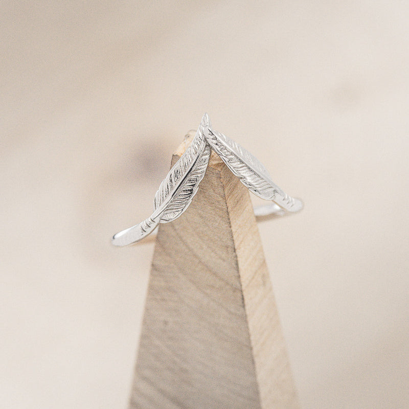 Shown here is "Fala", a feather-style tracer wedding band that is made to go with some of our engagement rings, on stand front facing (email for options).