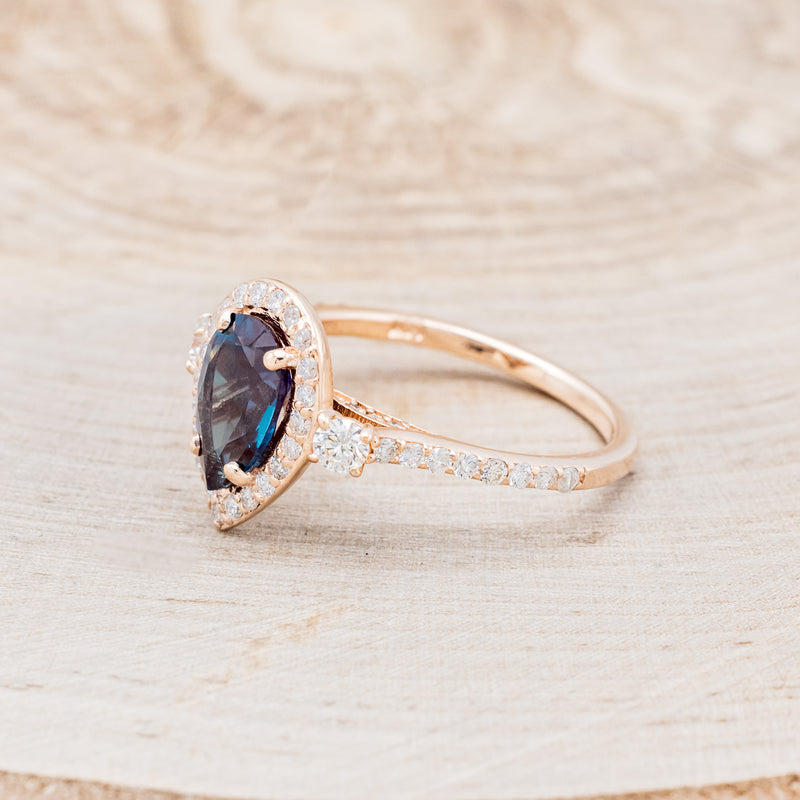 Shown here is "KB", a lab-created alexandrite women's engagement ring with diamond halo & accents, facing left. Many other center stone options are available upon request.
