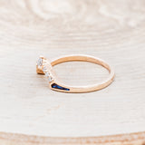 Shown here is "Sama", a 14K gold band with acrylic inlays and diamond accents, facing left.