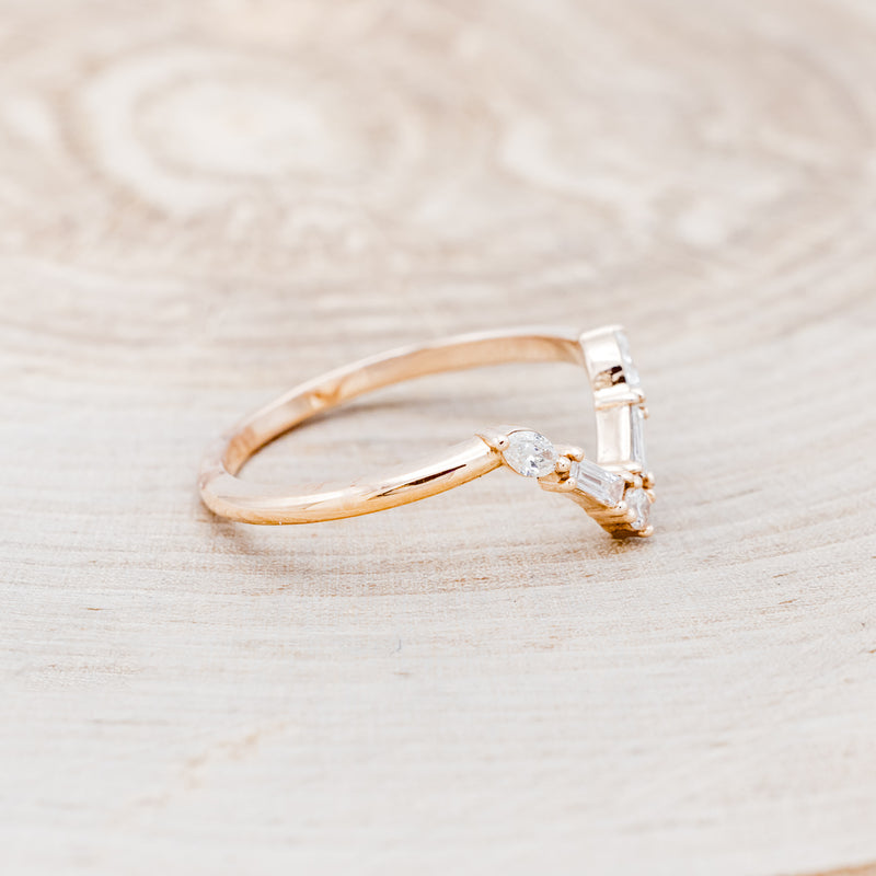 Shown here is "Melody", a 14K gold v-shaped band with diamond accents, facing right.