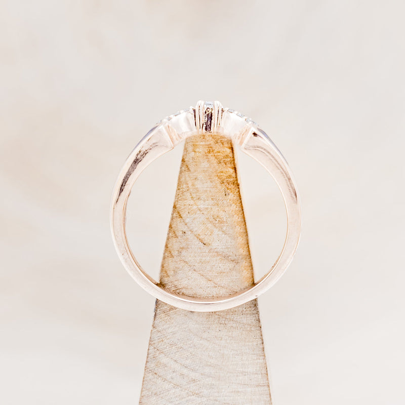 Shown here is "Sama", a 14K gold band with acrylic inlays and diamond accents, side view on stand.