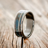 Shown here is "Raptor", a custom, handcrafted men's wedding ring featuring patina copper inlays, upright facing left.