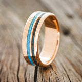 Shown here is "Cosmo", a custom, handcrafted men's wedding ring featuring 2 channels with a turquoise and a patina copper inlay, upright facing left. Additional inlay options are available upon request.
