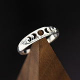 Shown here is "Nera", a handcrafted, custom wedding ring featuring the phases of the moon with two diamond accents. This ring is pictured in silver.