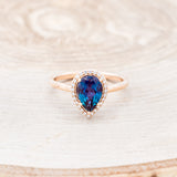 Shown here is "Clariss", a bridal suite-style lab-created alexandrite women's engagement ring with a diamond halo, front facing. Many other center stone options are available upon request.
