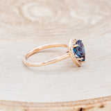 Shown here is "Clariss", a bridal suite-style lab-created alexandrite women's engagement ring with a diamond halo, facing right. Many other center stone options are available upon request.