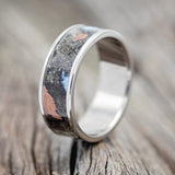 Shown here is "Rainier", a handcrafted men's wedding ring featuring buckeye burl wood as the base material with turquoise and copper inlays set into the burls, upright facing left. Additional inlay options are available upon request.