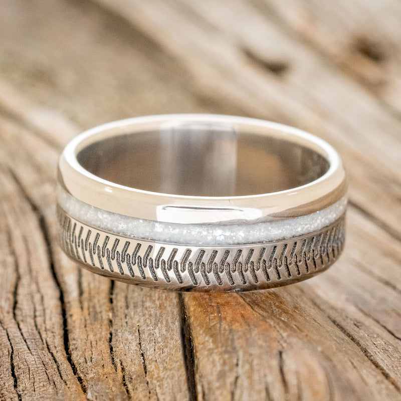 Shown here is "Vertigo", a custom engraved tire tread men's wedding ring featuring a diamond dust inlay, laying flat. Additional inlay options are available upon request.