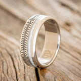 Shown here is "Vertigo", a custom engraved tire tread men's wedding ring featuring a diamond dust inlay, upright facing left. Additional inlay options are available upon request.