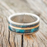 Shown here is "Raptor", a handcrafted men's wedding ring featuring two channels of patina copper and a 14K yellow gold inlay, laying flat. Additional inlay options are available upon request.