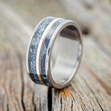 Shown here is "Raptor", a handcrafted men's wedding ring featuring two channels of patina copper and a 14K yellow gold inlay, upright facing left. Additional inlay options are available upon request.