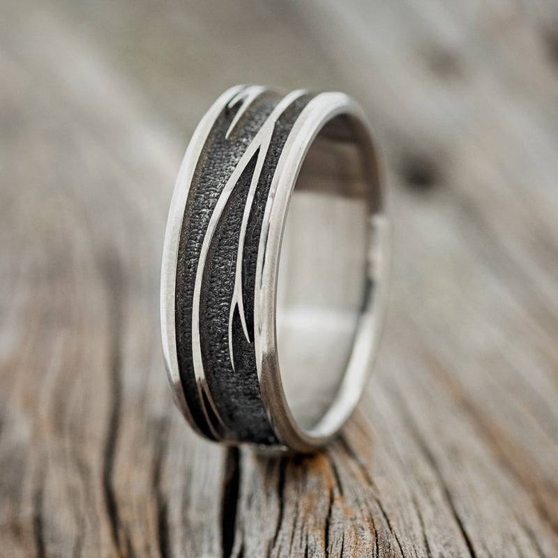 Shown here is "Legacy", a handcrafted, embossed men's wedding ring featuring a branch engraving in a channel-style band, upright facing left. It can be customized to feature just about any embossed design you can dream up.