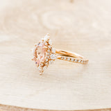  Shown here is "North Star", an oval morganite women's engagement ring with a diamond halo and diamond accents, facing left. Many other center stone options are available upon request.