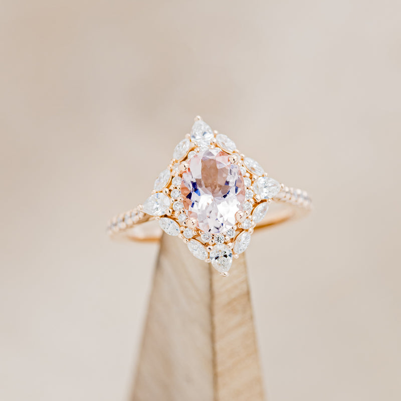 Shown here is "North Star", an oval morganite women's engagement ring with a diamond halo and diamond accents, on stand front facing. Many other center stone options are available upon request.