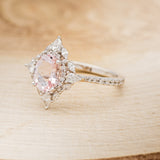 Shown here is "North Star", an oval morganite women's engagement ring with a diamond halo and diamond accents, facing left. Many other center stone options are available upon request.