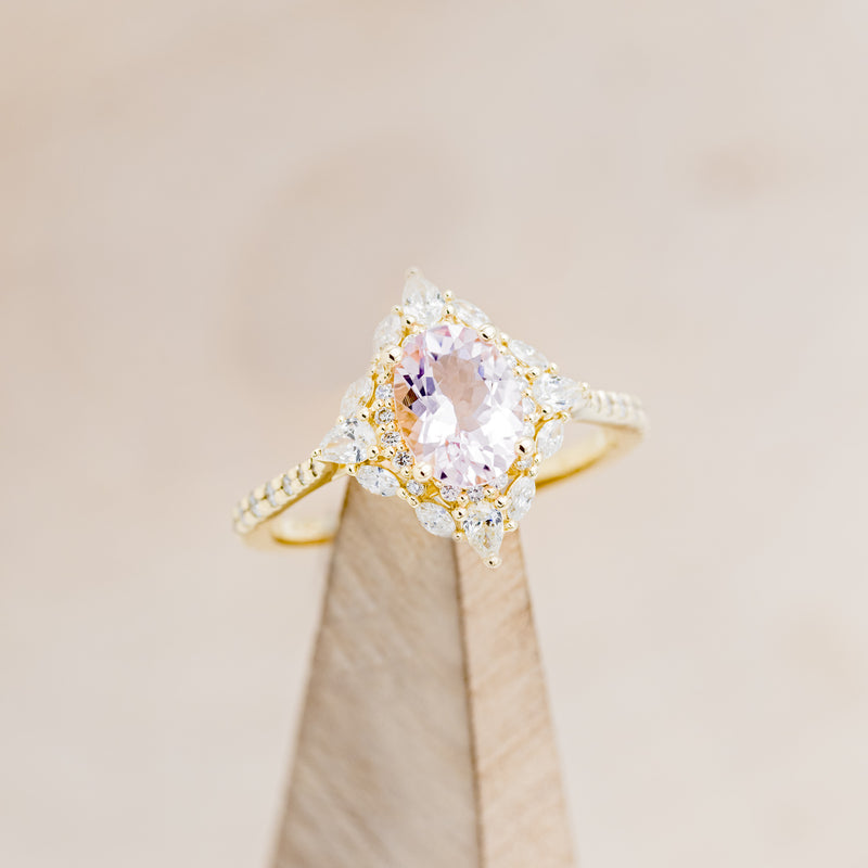 Shown here is "North Star", an oval morganite women's engagement ring with a diamond halo and diamond accents, on stand facing slightly right. Many other center stone options are available upon request.