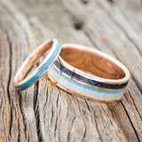 Shown here is a matching wedding band set featuring "Eterna" & "Element", laying together. "Element" is a handcrafted wide wedding band featuring antler, turquoise, and patina copper inlays. "Eterna" is a stacking-style wedding band featuring turquoise inlay.