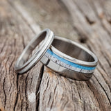 Shown here is a matching wedding band set featuring "Eterna" & "Castor", laying together. "Castor" is a handcrafted wide wedding band featuring antler and turquoise inlays. "Eterna" is a stacking-style wedding band featuring an antler inlay.
