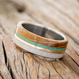Shown here is "Argos", a custom, handcrafted men's wedding ring featuring whiskey barrel oak and antler overlays with malachite and 14K rose gold inlays, tilted left. Additional inlay options are available upon request.
