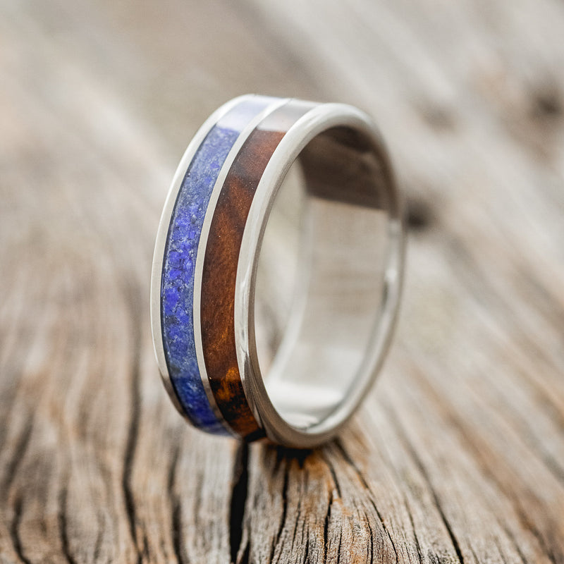 Shown here is "Dyad", a custom, handcrafted men's wedding ring featuring 2 channels with lapis lazuli and ironwood inlays, upright facing left. 