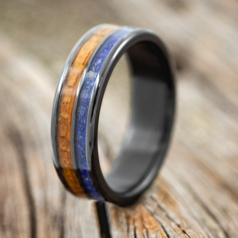 Shown here is "Dyad", a custom, handcrafted men's wedding ring featuring 2 channels with lapis lazuli and whiskey barrel inlays, upright facing left. Additional inlay options are available upon request.