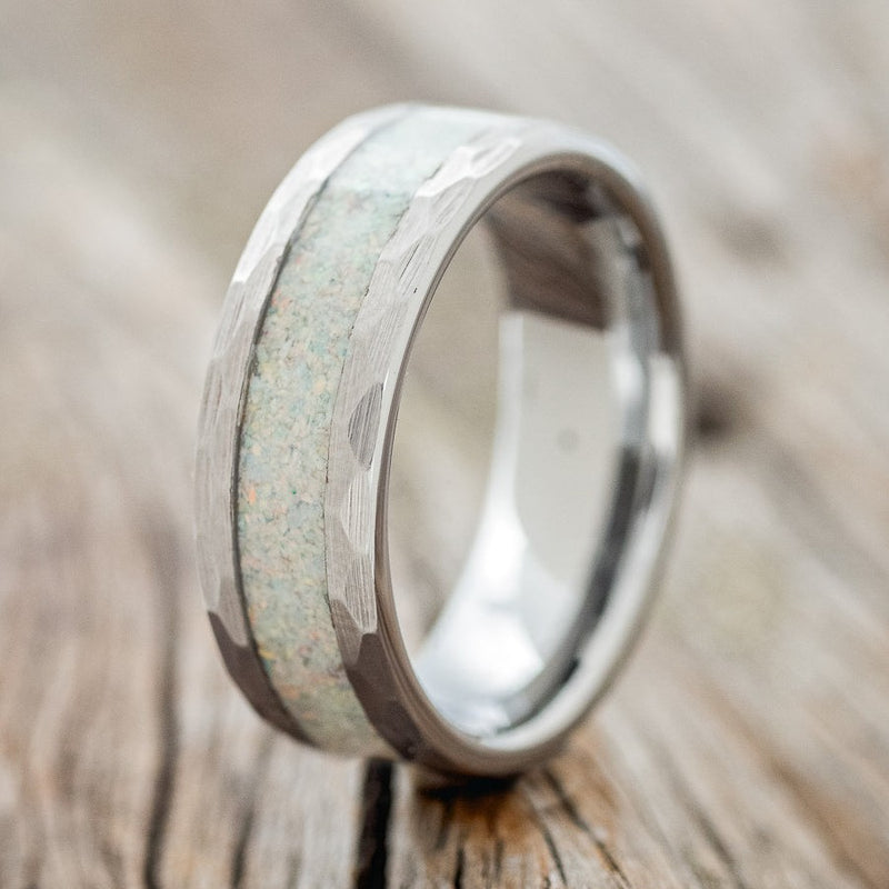 Shown here is a custom, handcrafted men's wedding ring featuring a fire & ice opal inlay with faceted edged Tungsten band, upright facing left. Additional inlay options are available upon request.