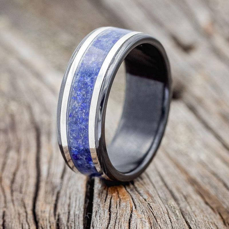 Shown here is "Hollis", a custom, handcrafted men's wedding ring featuring a lapis lazuli inlay and 2 14K white gold inlays, upright facing left. Additional inlay options are available upon request.