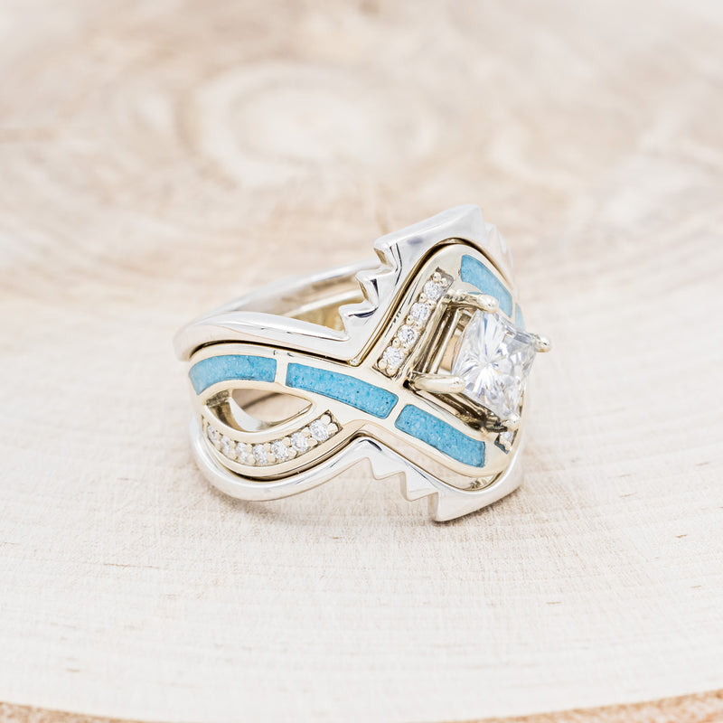 Shown here is "Helix", a geometric-style princess cut moissanite women's engagement ring with diamond accents and turquoise inlays, with tracers right facing. Many other center stone options are available upon request.