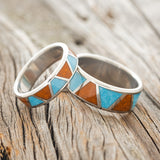 Shown here is "Powell", a custom, handcrafted matching set of wedding rings featuring terracotta & turquoise inlays, shown here on a titanium band, upright facing left. Additional inlay options are available upon request.