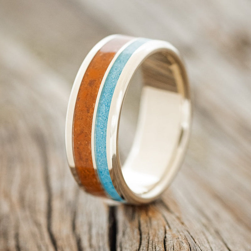 Shown here is "Raptor", a custom, handcrafted men's wedding ring featuring terracotta & turquoise inlays, upright facing left. Additional inlay options are available upon request.