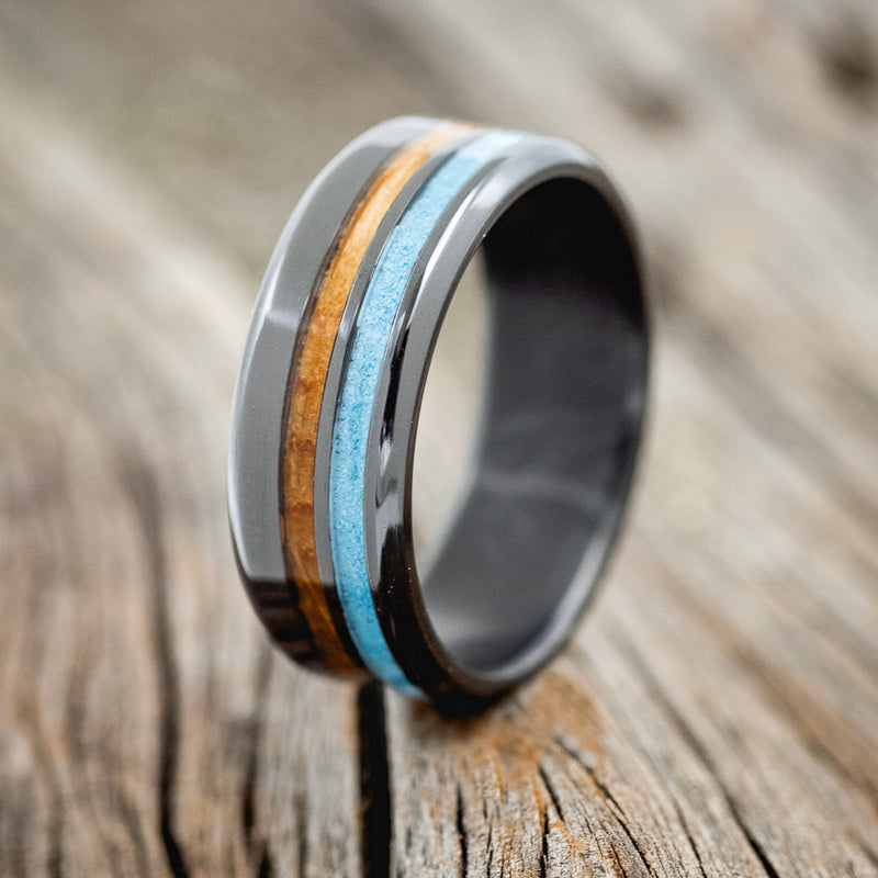 Shown here is "Cosmo", a custom, handcrafted men's wedding ring featuring whiskey barrel oak and turquoise inlays, upright facing left.