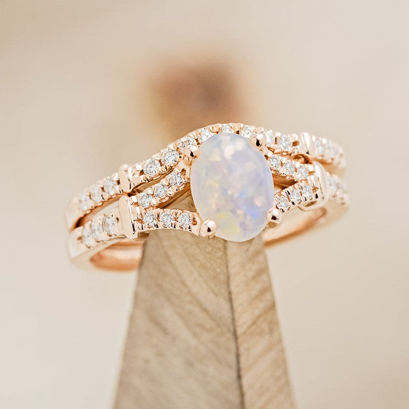 Shown here is "Evlin", a split shank-style opal women's engagement ring with tracer, on stand facing right, with delicate and ornate details and is available with many center stone options