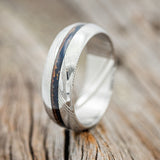 Shown here is "Nirvana", a custom, handcrafted men's wedding ring featuring a patina copper inlay, shown here on a domed Damascus steel band, upright facing left. Additional inlay options are available upon request.