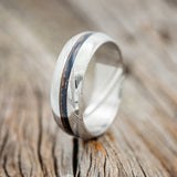 Shown here is "Nirvana", a custom, handcrafted men's wedding ring featuring a patina copper inlay on a domed band, upright facing left. 