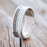Shown here is "Dyad", a custom, handcrafted men's wedding ring featuring 2 channels with diamond dust and black fire opal inlays, upright facing left. Additional inlay options are available upon request.