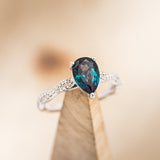 Shown here is a lab-created alexandrite women's engagement ring with diamond accents, on stand facing slightly right. Many other center stone options are available upon request.