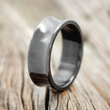Shown here is a handcrafted men's wedding ring featuring a concave, fire-treated black zirconium band, upright facing left. Additional inlay options are available upon request.