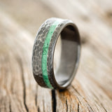 Shown here is "Vertigo", a custom, handcrafted men's wedding ring featuring a malachite inlay with a hammered finish, upright facing left. 