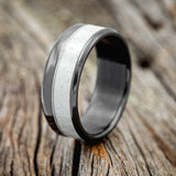 Shown here is "Tanner", a custom, handcrafted men's wedding ring featuring a naturally shed elk antler inlay, upright facing left. Additional inlay options are available upon request