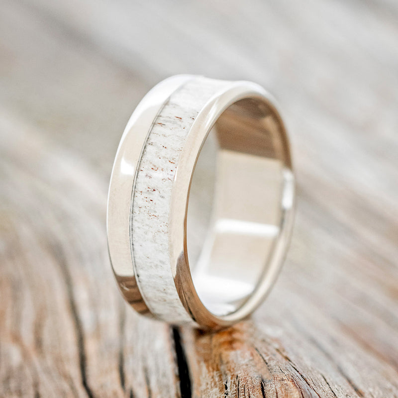 Shown here is "Tanner", a handcrafted men's wedding ring featuring an antler inlay, upright facing left. 