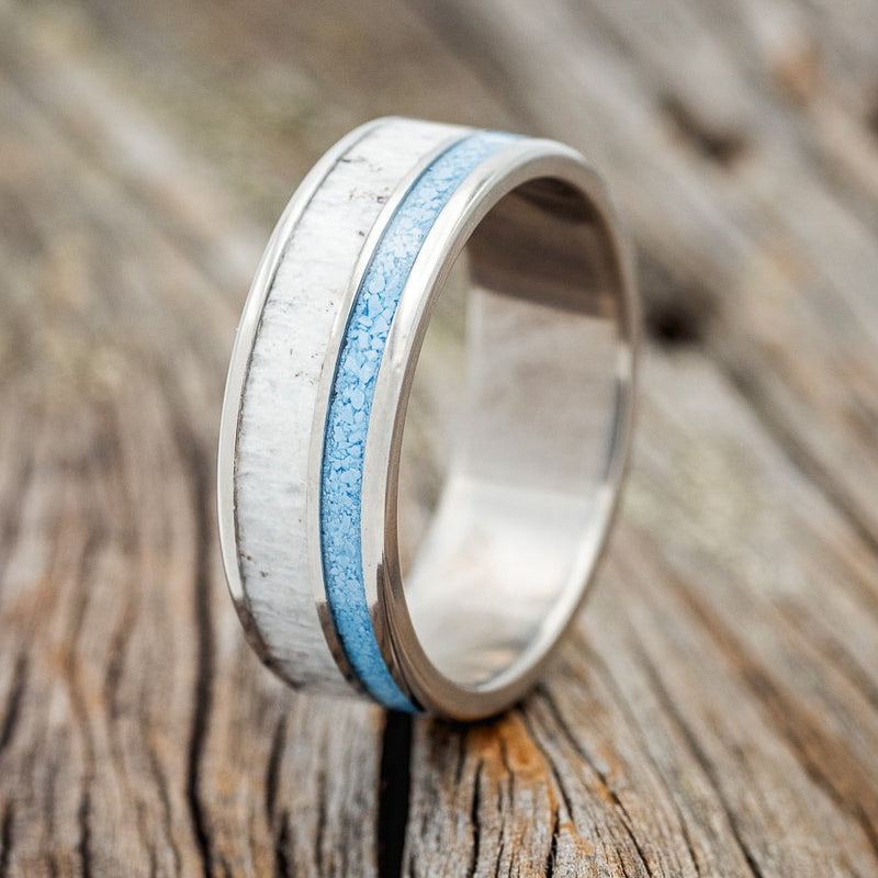 Shown here is "Raptor", a custom, handcrafted men's wedding ring featuring a turquoise & antler inlay, upright facing left. Additional inlay options are available upon request.