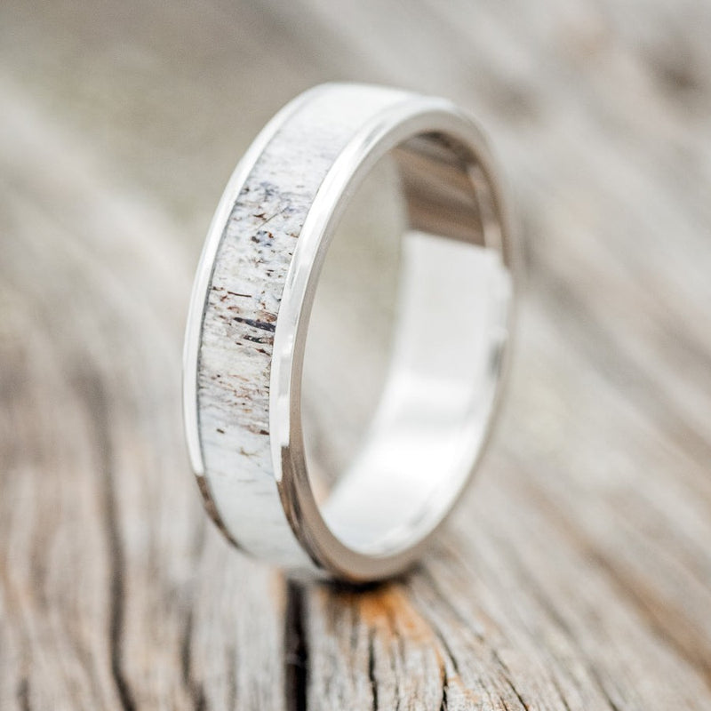 Shown here is "Rainier", a custom, handcrafted men's wedding ring featuring an elk antler inlay, upright facing left. Additional inlay options are available upon request.