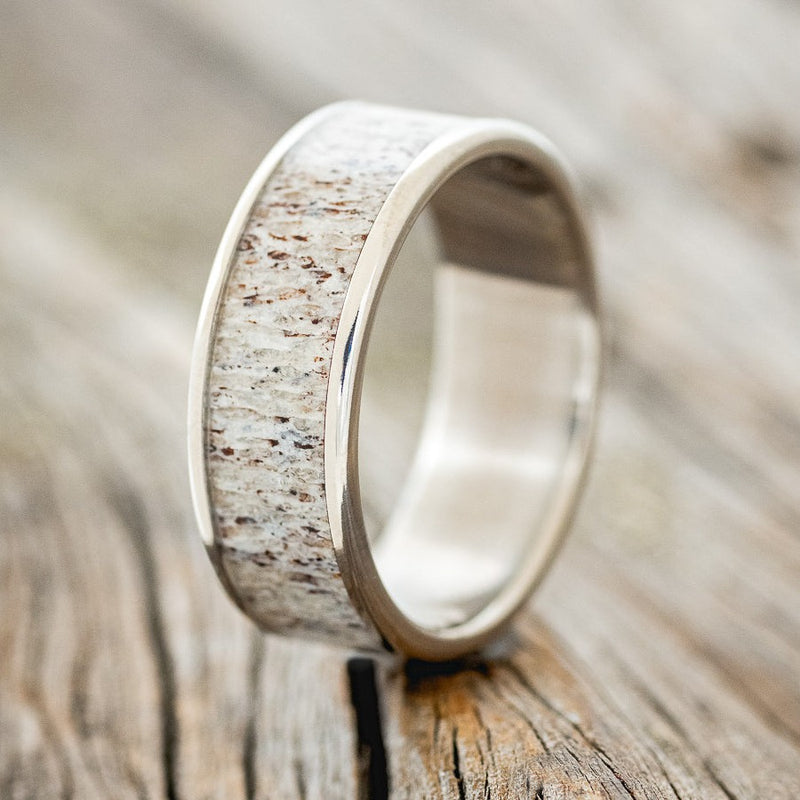 Shown here is "Rainier", a custom, handcrafted men's wedding ring featuring an antler inlay, upright facing left. Additional inlay options are available upon request.