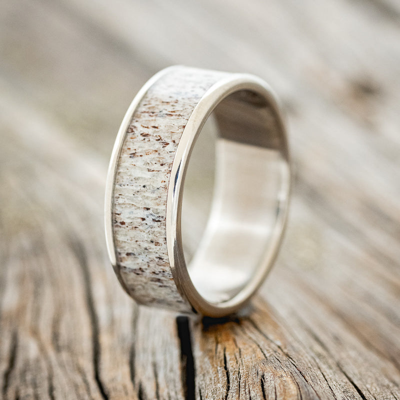 Shown here is "Rainier", a handcrafted men's wedding ring featuring an antler inlay, upright facing left. 