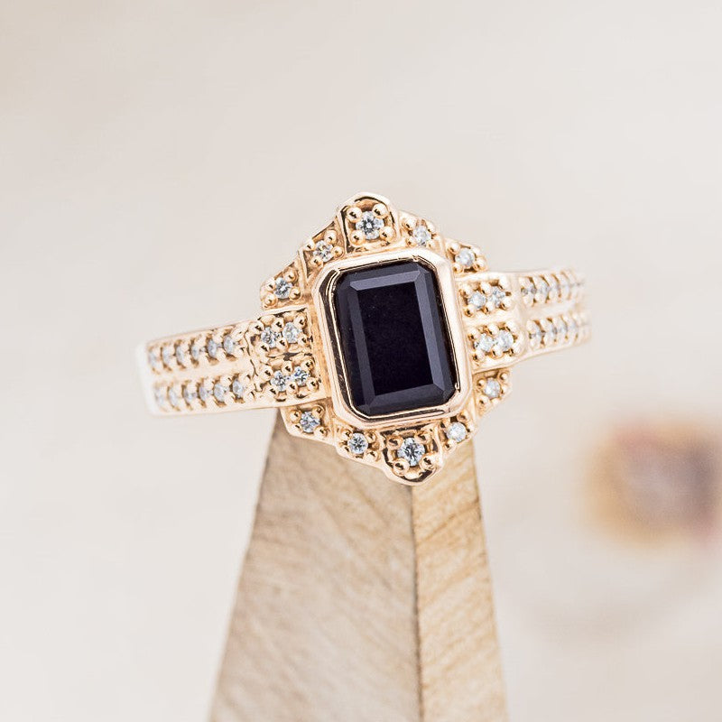 Shown here is "Elenor", an emerald cut black onyx women's engagement ring with diamond accents, on stand facing slightly right. Many other center stone options are available upon request.