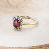 Shown here is "Cleopatra", an art deco-style oval garnet women's engagement ring with diamond accents, facing left. Many other center stone options are available upon request.