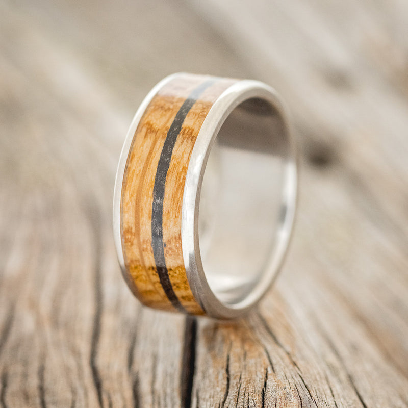 Shown here is "Rainier", a custom, handcrafted men's wedding ring featuring a whiskey barrel and charred whiskey barrel inlay, upright facing left.