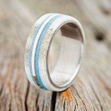 Shown here is "Canyon", a custom, handcrafted men's wedding ring featuring an antler and turquoise overlay with a 14K rose gold inlay, upright facing left. Additional inlay options are available upon request.