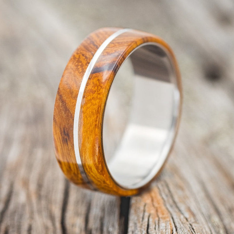 Shown here is "Golden", a custom, handcrafted men's wedding ring featuring ironwood overlays, upright facing left. Additional overlay options are available upon request.